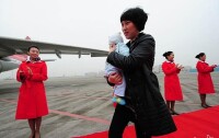 2012年11月6日蔣敏懷抱孩子赴京參加十八大
