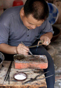 國家級“工藝大師”李光雄在加工銀飾