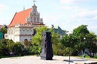盧布林猶太人大屠殺紀念碑，背景是多米尼加教堂