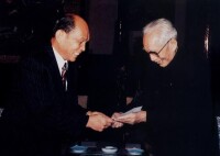 （圖）1986年11月29日，首任理事長王震接受香港中華總商會會長霍英東捐款500萬元港幣